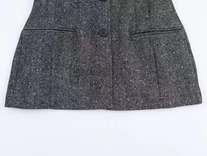 Detailed macro view of gray herringbone wool fabric texture and pocket on blazer jacket