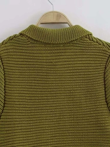 Dettaglio della trama in maglia a coste verde e del colletto a bavero sulla gruccia