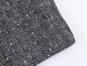 Macro detail of high-quality black and white herringbone wool fabric for autumn blazer