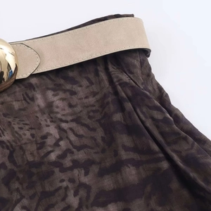 Close-up of leopard print midi skirt featuring a beige faux leather belt and gold buckle