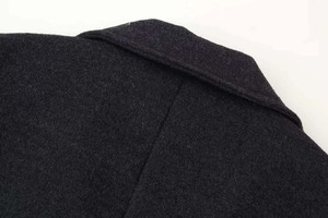 Dettaglio ravvicinato di cappotto in lana grigio antracite con risvolto e tessuto spesso
