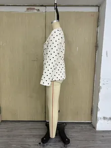 Seitenansicht eines weißen taillierten Blazers mit schwarzen Punkten auf einer Schaufensterpuppe