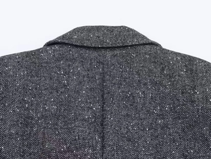 Detailed macro view of herringbone tweed texture on autumn blazer collar and shoulder