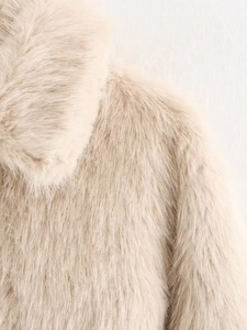 Detail of beige faux fur coat collar and shoulder area showing soft plush texture
