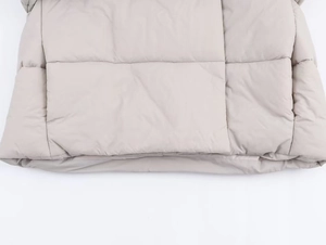 Detail view of horizontal wide quilting and matte fabric on a hooded winter puffer coat