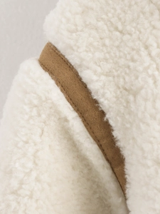Détail d'une veste en polaire blanc cassé avec passepoil en tissu marron contrastant