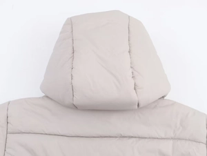 Detail view of winter padded jacket showing the integrated hood and quilted fabric texture