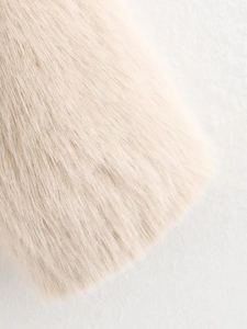 Close-up of soft beige faux fur material with silky texture and smooth fibers