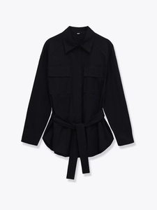 Detail einer schwarzen Langarm-Hemdjacke mit Gürtel und symmetrischen Brusttaschen