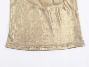Macro detail of champagne gold metallic fabric with fine vertical texture and neat stitching