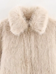 Detail of light beige faux fur coat featuring soft texture and gold zipper closure