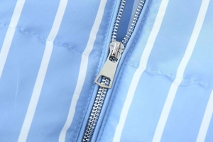 Detail of blue and white striped puffer jacket showing the silver metal zipper close-up