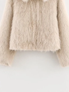 Detail of soft cream faux fur jacket showing plush texture and hemline craftsmanship
