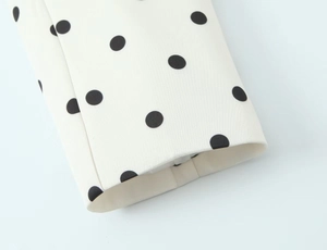 Detailansicht der Damen-Blazer-Manschette mit klassischem schwarzen Polka-Dot-Muster auf Weiß