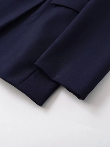 Gros plan détaillé sur le tissu sergé bleu marine et les coutures de qualité de la veste