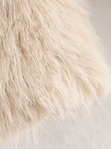 Macro shot of soft faux fur texture on a beige winter coat showing fine fluffy fibers