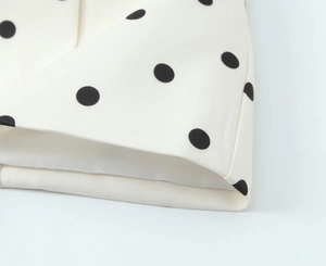 Detailansicht eines weißen Blazers mit schwarzen Punkten, Baumwolltwill und Doppelnaht