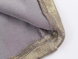 Detail of grey ribbed fabric with metallic gold lurex threads and overlock stitching
