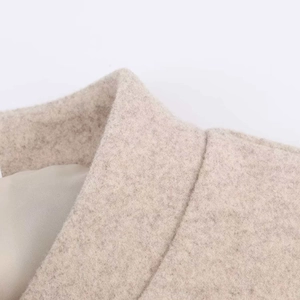 Gros plan sur le tissu en laine avoine de qualité supérieure et les coutures du col