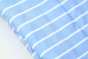 Macro shot of light blue and white horizontal striped fabric for puffer jackets