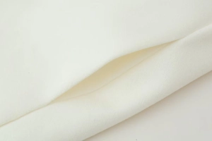Detailaufnahme von hochwertigem weißem Wollstoff mit professionellen Nähten am Mantel
