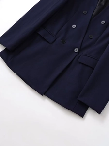Détail d'un blazer croisé bleu marine montrant la texture sergé et la poche à rabat