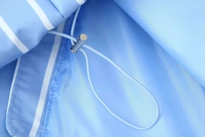 Detail of adjustable drawstring with silver metal toggle on blue striped puffer coat
