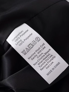 Étiquette d'entretien détaillée montrant 100% polyester pour la veste de costume noire