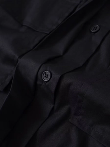 Detail eines schwarzen Langarmhemdes mit hochwertiger Stoffstruktur und Knöpfen