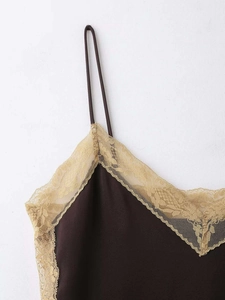 Détail du caraco en satin marron foncé avec une bordure en dentelle de cils beige