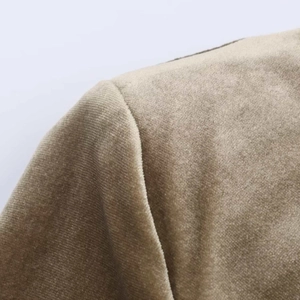 Detail of shoulder seam and pleated pad on beige velvet long sleeve dress fabric