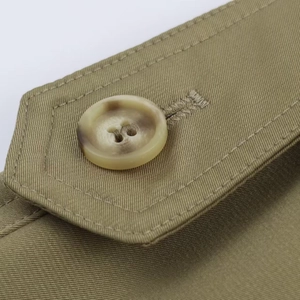 Macro view of amber-textured resin button and neat stitching on khaki twill jacket fabric