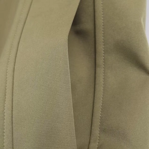 Detailed macro view of khaki twill fabric and reinforced double stitching on the side pocket