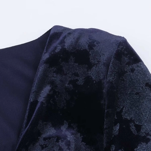 Detailed view of deep blue velvet dress shoulder with floral embossed texture and stitching