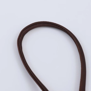 Detail of dark brown satin shoulder strap with refined cylindrical stitching and silk texture