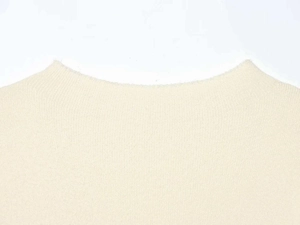 Detailed close-up of the fine knit texture and crew neckline on an off-white sweater