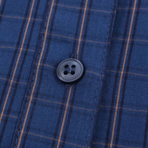 Macro shot of dark blue plaid shirt fabric showing detailed weaving and resin button