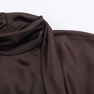 Gros plan sur le satin de soie marron chocolat montrant les détails d'un col drapé chic
