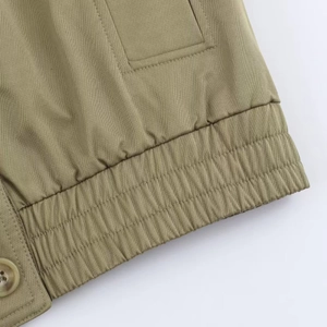 Detail shot of khaki jacket featuring twill fabric, elastic hem, and neat stitching
