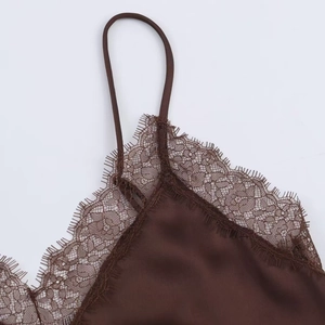 Close-up of brown satin camisole top featuring delicate eyelash lace trim and thin straps