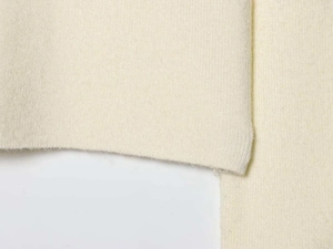 Close-up of beige knit fabric texture showing the soft fine ribbed material detail