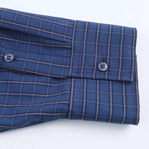 Detailed macro view of sleeve cuffs on a blue plaid shirt with resin buttons