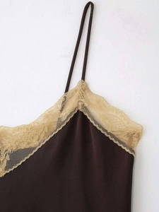 Détail d'un caraco en satin marron chocolat avec bordure délicate en dentelle dorée