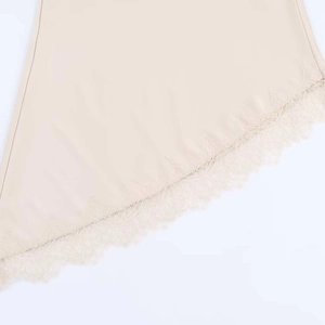 Detail of elegant eyelash lace trim and asymmetric hem on beige satin midi skirt