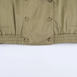 Detail of cropped jacket showing marble buttons and elastic drawstring hemline