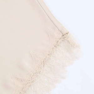 Détail de la jupe midi élégante en satin champagne avec bordure en dentelle de cils fine