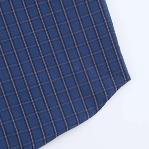 Macro detail of dark blue vintage plaid fabric with yellow stripes and curved hemline