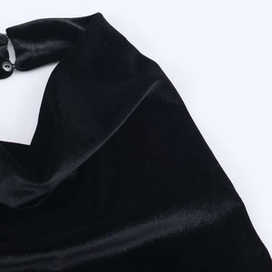 Close-up of black velvet dress neck detail with two elegant round matching buttons