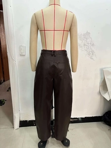 Dettaglio dei pantaloni a vita alta in ecopelle marrone scuro con tasche posteriori