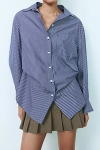 Detail of blue striped long sleeve shirt texture and brown houndstooth pleated skirt